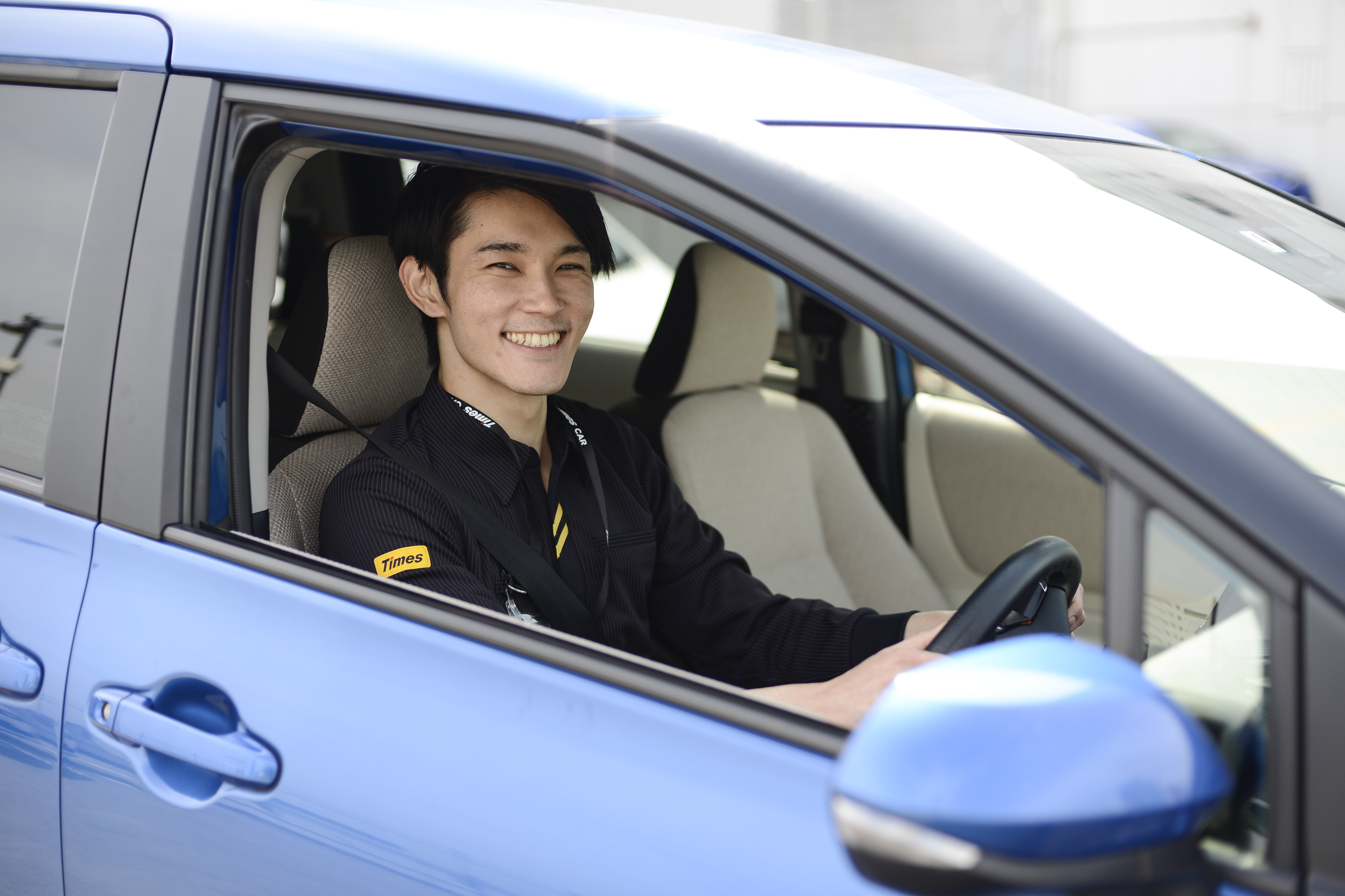 男性_運転_ブルーの車体